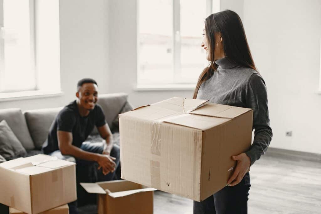 A young couple packing - boxes are sealed on the sides and bottoms