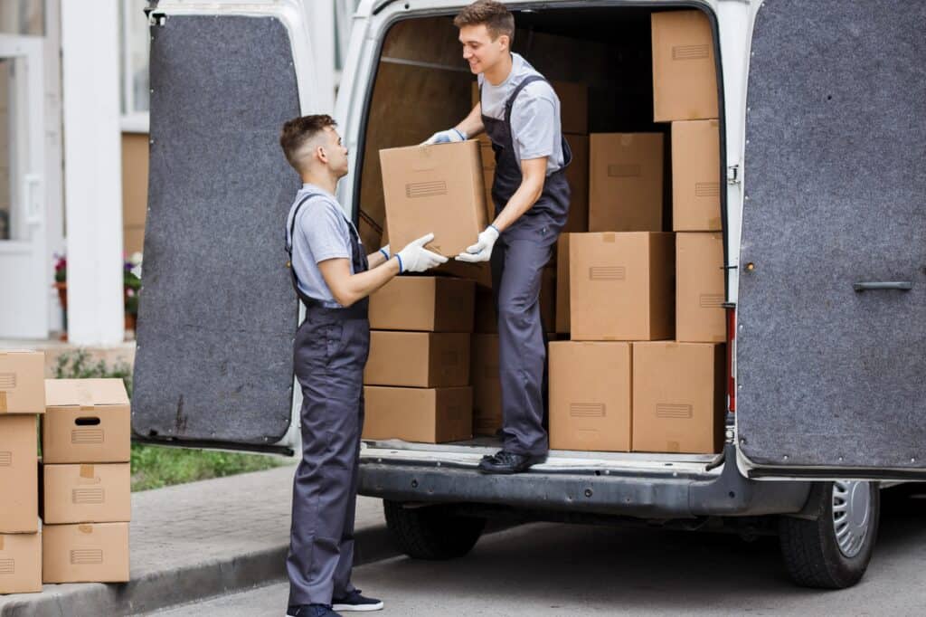 Two movers unloading the van - experienced packers handling fragile items